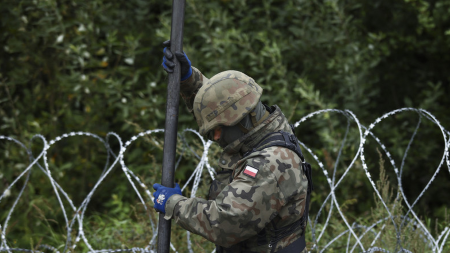Un soldat polonais réajuste une clôture en fil de fer barbelé à la frontière avec la Biélorussie, le 26 août 2021. © Jaap Arriens Source: AFP
