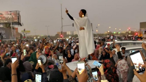 Cette image d'Ala'a Salah, chantant la «révolution» au milieu d'une foule de manifestants à Khartoum, lundi 8 avril, a fait le tour des réseaux sociaux. © Courtesy Lana H. Haroun/via REUTERS