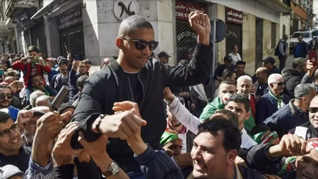 Le journaliste algérien Khaled Drareni porté par les manifestants après avoir été brièvement détenu par les forces de police, à Alger le 6 mars 2020. RYAD KRAMDI / AFP