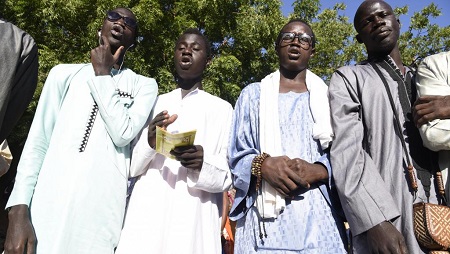 Des membres de la confrérie mouride chantent aux abords du tribunal où le maître d'une école coranique est jugé pour avoir enchaîné ses élèves, le 2 décembre 2019, à Louga, au Sénégal. © SEYLLOU / AFP
