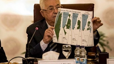 Le président de l'Autorité palestinienne, Mahmoud Abbas, montre des cartes de la Palestine où l'on voit le plan de partition de l'ONU de 1947, les frontières de 1948-67 et une carte sans les zones annexées par Israël, au Caire, le 1er février 2020. Khaled DESOUKI/AFP