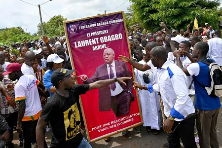 Des partisans de Laurent Gbagbo agitent une affiche créée pour son retour en Côte d'Ivoire. L'acquittement de l'ancien président a été confirmé en appel par la Cour pénale internationale le 31 mars 2021. © Sia Kambou / AFP