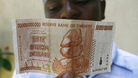 Un homme tient un billet de 50 milliards de dollars zimbabwéens en 2009. © AFP Photo/Desmond Kwande
