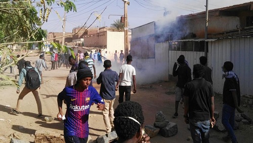 Des manifestants soudanais cherchent à se protéger des gaz lacrymogènes lors d'une manifestation antigouvernementale dans le district de Burri, dans la capitale soudanaise, à Khartoum, le 24 février 2019. © STRINGER / AFP