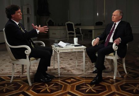 Vendredi 9 février 2024, Vladimir Poutine, à droite, fait un geste pendant qu'il parle lors d'une interview avec l'ancien animateur de Fox News Tucker Carlson