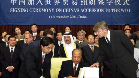 Le ministre du Commerce international chinois, Shi Guangsheng, signe le document d'adhésion de la Chine à l'OMC au troisième jour de la conférence de Doha, le 11 novembre 2001. (NH/RKR/Reuters)
